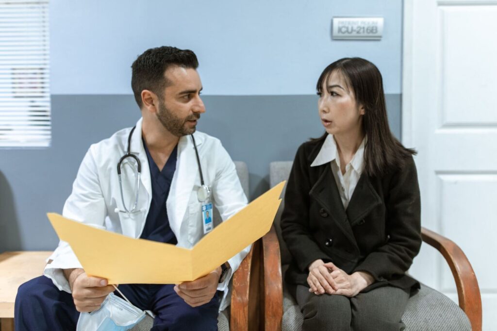 Cena real de consulta em consultório, com médico e paciente conversando sentados, em ambiente claro e acolhedor, sem exposição corporal.